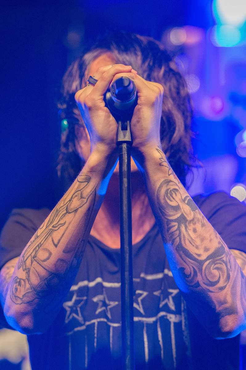 tattoo man holding black microphone clive